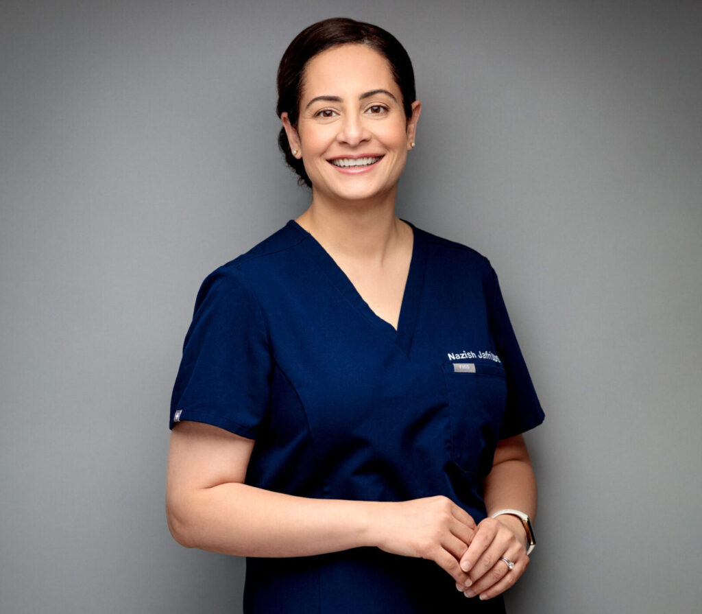 Portrait of Dr. Nazish Jafri smiling in blue scrubs