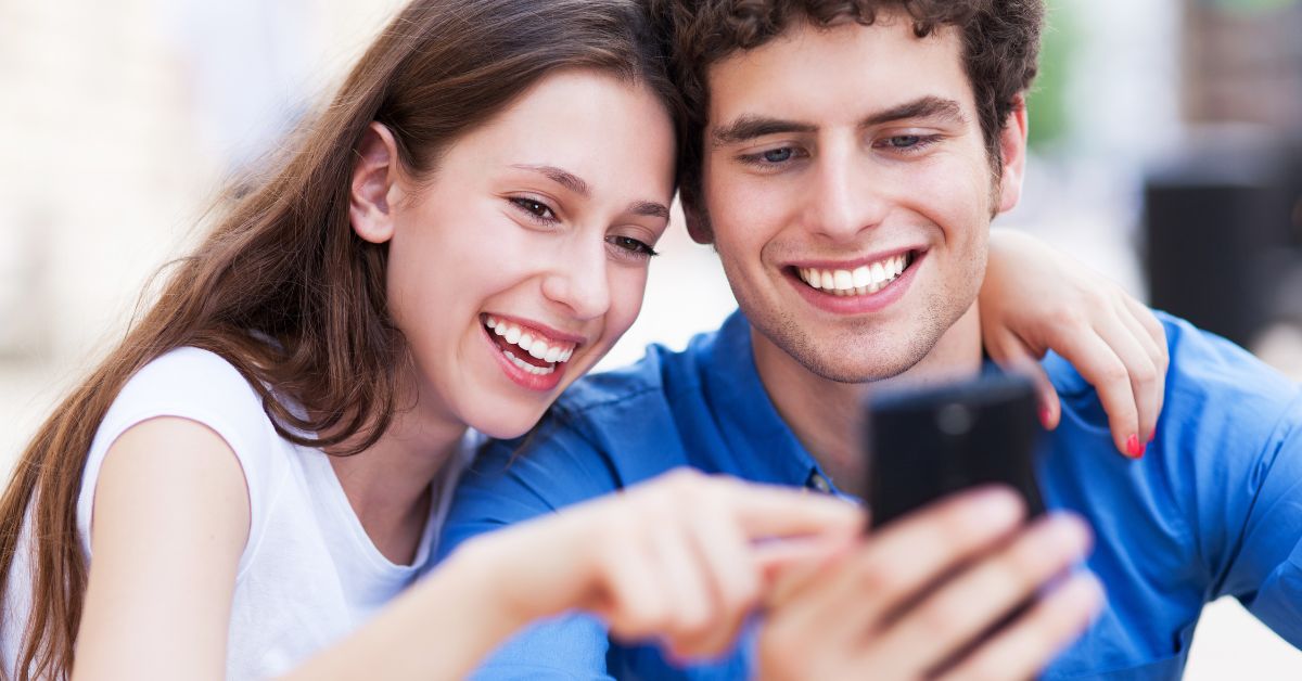 two adults looking at the phone for the Best dentist near me