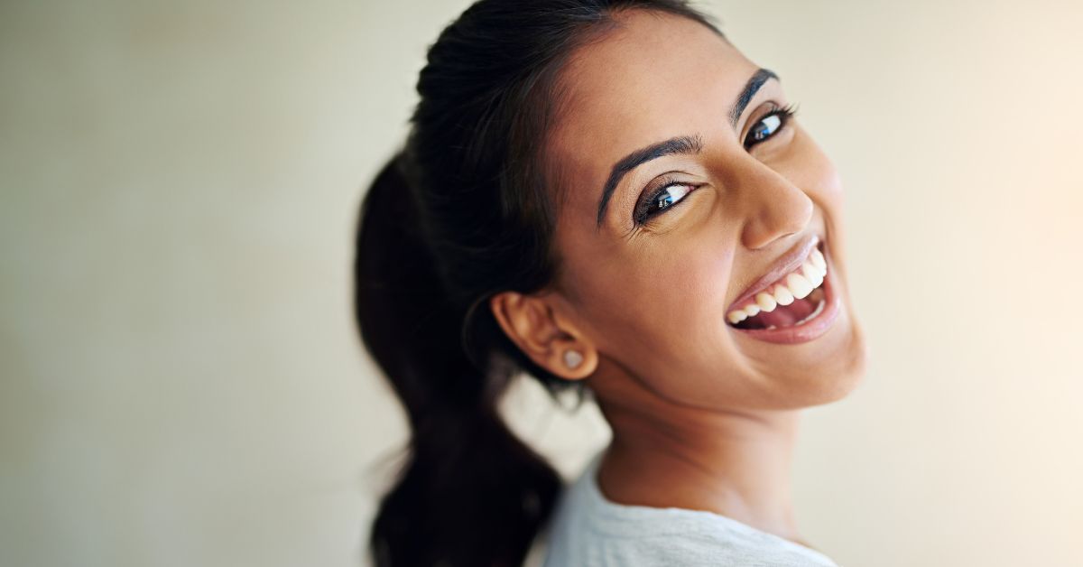 adult smiles after learning How to keep teeth clean with clear aligners